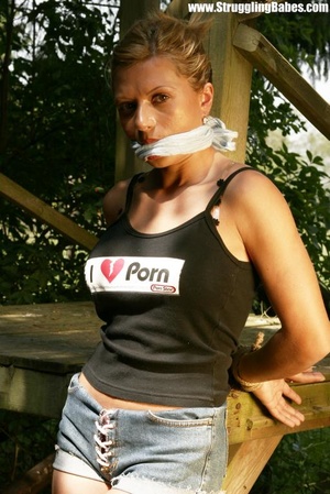 Sexy brunette in black top and jeans shorts gagged and tied hands back outdoors - XXXonXXX - Pic 7