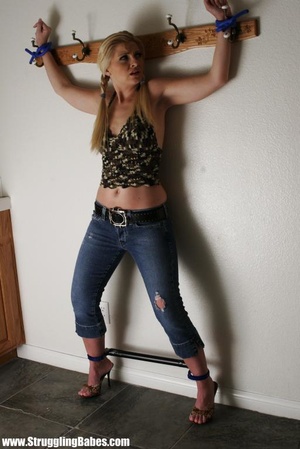Tasty blonde in sexy top and jeans pants bound hands and legs apart - Picture 1