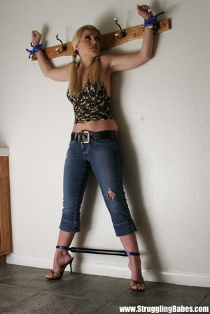 Tasty blonde in sexy top and jeans pants bound hands and legs apart - Picture 2