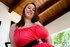 Fat redheaded model in red getting on all fours on a sofa