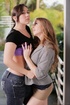 Lesbians posing next to each other and kissing outdoors