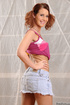Pigtailed teen in pink top and jeans miniskirt undressing and posing in