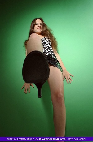 Luscious granny displays her steaming hot body then shows her hairy crack in different poses wearing her black and white dress and black high heels in a green room. - Picture 7