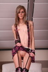 Skinny blonde in suspenders teases her pink pussy under her skirt.