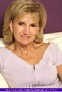 Luscious granny pose her mature body as she sits on a white couch wearing