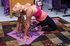 Busty blonde in a bright pink cami and black yoga pants does a different