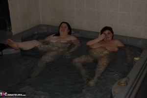 Two big breasted BBWs are sharing a hot bath together while being filmed - Picture 1