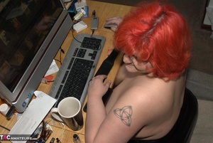 Chubby redhead with huge set of boobs is masturbating in front of a computer - Picture 1
