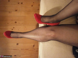 Hot blonde MILF teases with her sexy legs, while wearing dark stockings and red shoes - Picture 18