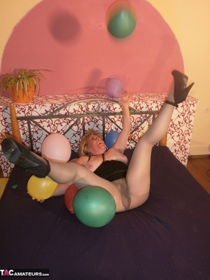 Blonde cougar plays with balloons and shows her massive tits to the cam - Picture 5