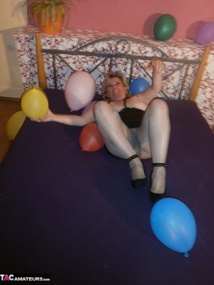 Blonde cougar plays with balloons and shows her massive tits to the cam - Picture 6