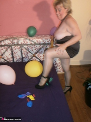 Blonde cougar plays with balloons and shows her massive tits to the cam - Picture 13