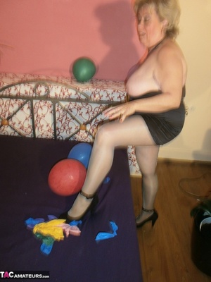 Blonde cougar plays with balloons and shows her massive tits to the cam - Picture 16