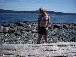 This blonde tramp in a bikini shows off her slutty body as she poses beach-side - XXXonXXX - Pic 1