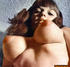 A horny, ginger, tramp in black stockings and heels poses with her big