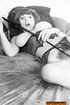 A milf, with perky tits poses topless and displays her hairy pussy