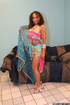Brown eyed brunette with big breast posing by the couch in pink indian