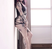 Tattooed hot goth purple hair chick in black dress flaunts seductive colorful