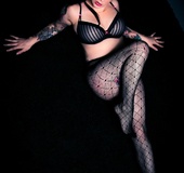 Inviting cute tattooed brunette in black bra and net tights shows tits