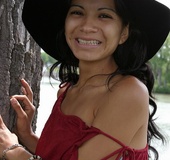 Foxy chick pose her alluring body wearing black hat, red blouse and multi