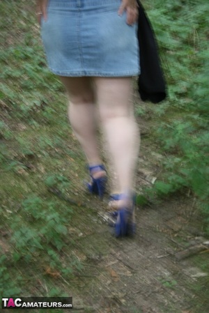 Chubby granny pose in the woods then peels off her black shirt and releases her giant tits before she pulls down her jeans skirt and teases with her humongous ass then pulls down her blue panty and expose her lusty pussy wearing her blue high heels. - XXXonXXX - Pic 6