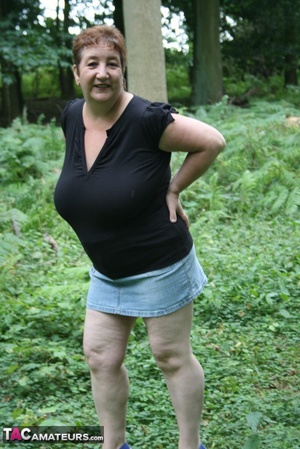 Mature BBW displays her plus size body in black shirt, jeans skirt and blue high heels then shows her extra large boobs in the woods. - Picture 4