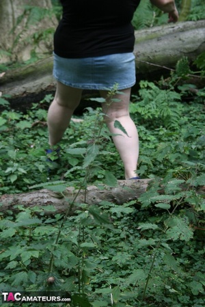Mature BBW displays her plus size body in black shirt, jeans skirt and blue high heels then shows her extra large boobs in the woods. - Picture 6