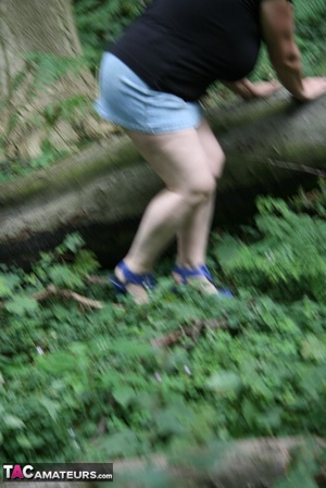 Mature BBW displays her plus size body in black shirt, jeans skirt and blue high heels then shows her extra large boobs in the woods. - Picture 7