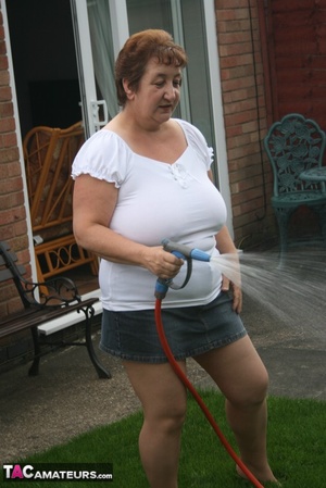 Plus size granny gets her big body wet with a hose on her lawn before she pulls down her jeans skirt and expose her lusty pussy then lifts up her white shirt and expose her humongous juggs. - XXXonXXX - Pic 3