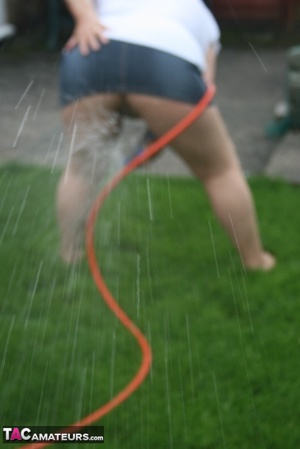 Plus size granny gets her big body wet with a hose on her lawn before she pulls down her jeans skirt and expose her lusty pussy then lifts up her white shirt and expose her humongous juggs. - XXXonXXX - Pic 6