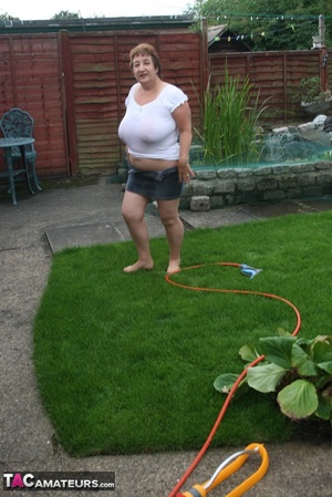 Plus size granny gets her big body wet with a hose on her lawn before she pulls down her jeans skirt and expose her lusty pussy then lifts up her white shirt and expose her humongous juggs. - XXXonXXX - Pic 9