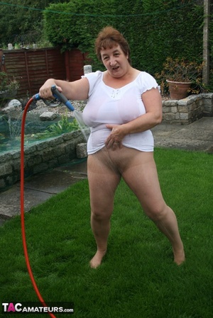 Plus size granny gets her big body wet with a hose on her lawn before she pulls down her jeans skirt and expose her lusty pussy then lifts up her white shirt and expose her humongous juggs. - XXXonXXX - Pic 13
