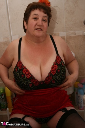 Alluring granny peels off her red dress and seduces with her plus size body in red and black lingerie, black stockings and red high heels in different poses in the bathroom. - XXXonXXX - Pic 16