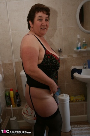 Alluring granny peels off her red dress and seduces with her plus size body in red and black lingerie, black stockings and red high heels in different poses in the bathroom. - XXXonXXX - Pic 20