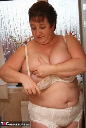 Mature BBW takes off her white robe and gets her plus size body wet wearing her white lingerie and skin tone stockings before she expose her giant breasts then pulls down her panty and bares her lusty crack while she takes a shower. - Picture 8