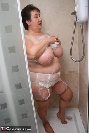 Mature BBW takes off her white robe and gets her plus size body wet wearing her white lingerie and skin tone stockings before she expose her giant breasts then pulls down her panty and bares her lusty crack while she takes a shower. - Picture 19