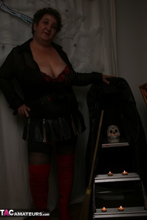 Hot granny takes off her black jacket and teases with her monster tits and chubby body in red and black lingerie, black skirt, stockings and red boots. - Picture 8