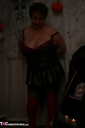 Hot granny takes off her black jacket and teases with her monster tits and chubby body in red and black lingerie, black skirt, stockings and red boots. - Picture 11