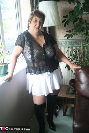 Hot granny peels off her black blouse and teases with her plus size body then shows her gigantic breasts wearing her white lingerie, skirt and black boots in different poses. - XXXonXXX - Pic 3