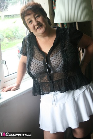 Hot granny peels off her black blouse and teases with her plus size body then shows her gigantic breasts wearing her white lingerie, skirt and black boots in different poses. - XXXonXXX - Pic 4