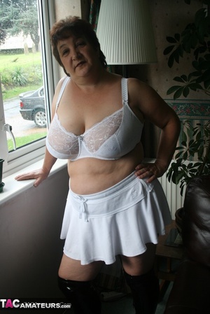 Hot granny peels off her black blouse and teases with her plus size body then shows her gigantic breasts wearing her white lingerie, skirt and black boots in different poses. - XXXonXXX - Pic 16