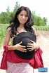 Black haired lass in red top and black hat undressing outdoors and exposing