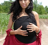 Black haired lass in red top and black hat undressing outdoors and exposing