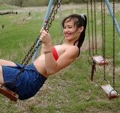 Hairy pussy brunette with red lollipop swinging outdoors in red top and
