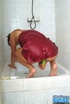 Short haired brunette taking a shower in red peignoir before sucking and