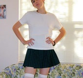 Short haired brunette in white socks wiggles out of white top and dark