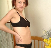 Older redhead in green outfit and black undies slowly getting nude and