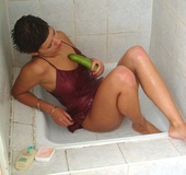 Short haired brunette in red peignoir toying her hairy pussy with cucumber