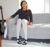Pigtailed brunette in pink skirt and white hose teasing on the couch and