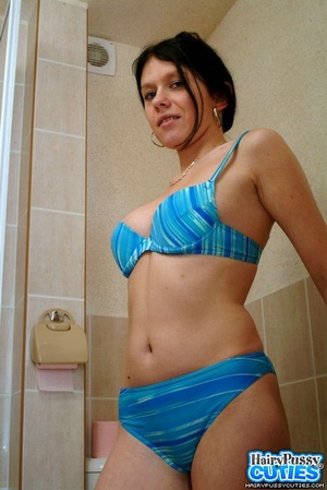 Black haired chick in blue bikini undressing and taking a shower before fingering her bushy cunt - Picture 1